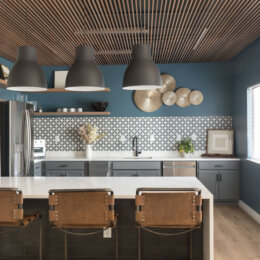 A remodeled kitchen in a leasing clubhouse, with wood slat ceiling and bold patterned backsplash